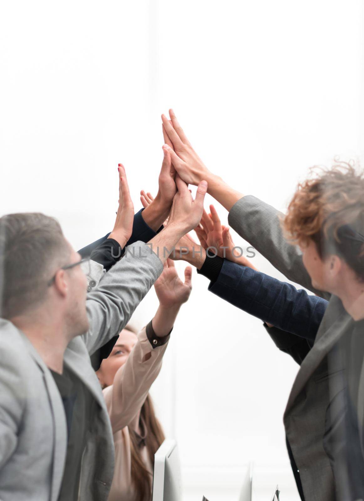 close up. a group of happy employees giving each other a high five.