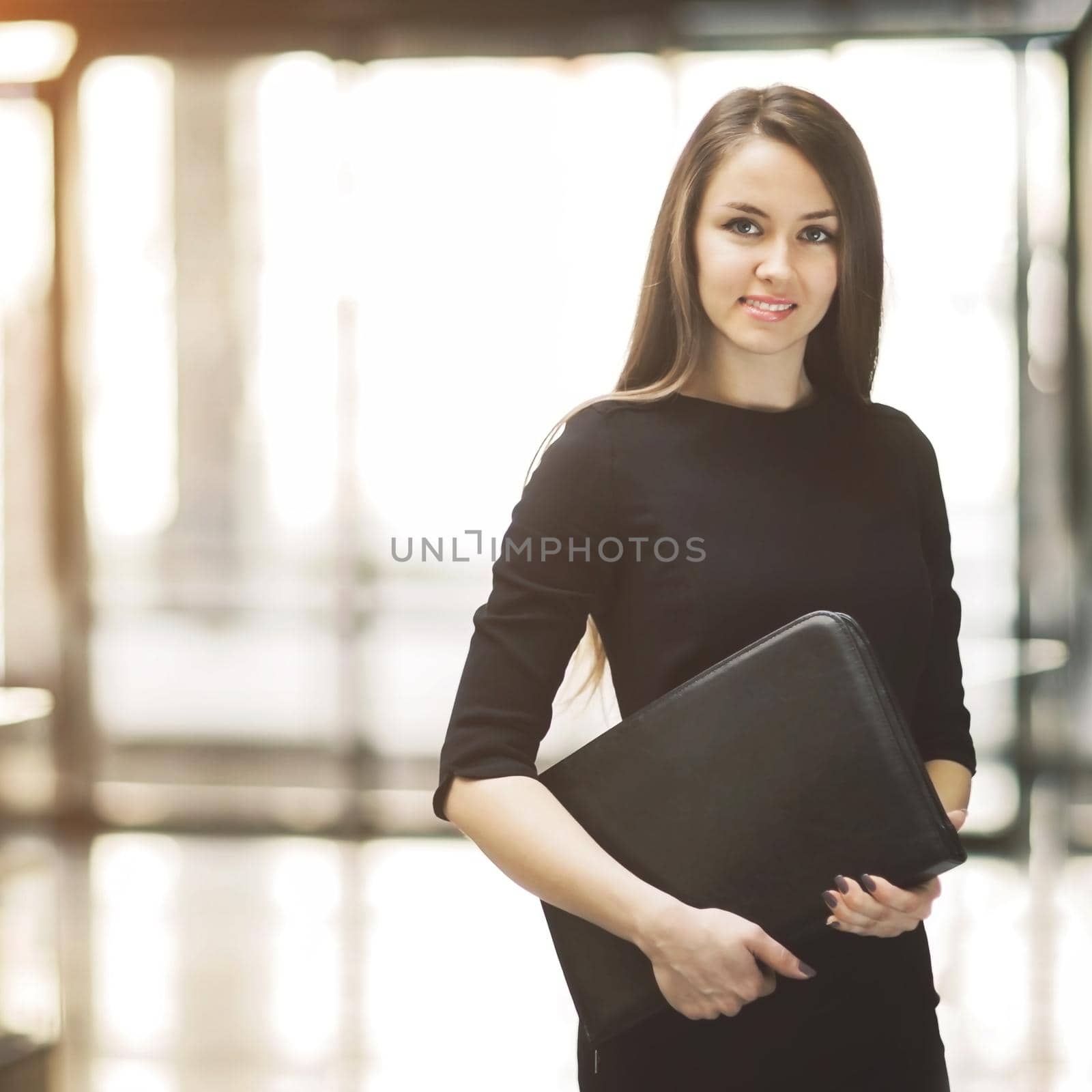 Portrait of cute young business woman smiling in the office, the hands of the folder by SmartPhotoLab