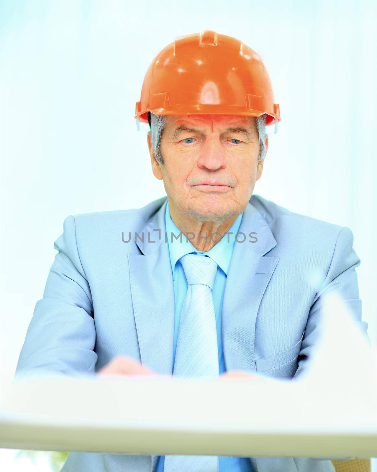 Engineer at the age of considering plans drawing and corrects them.