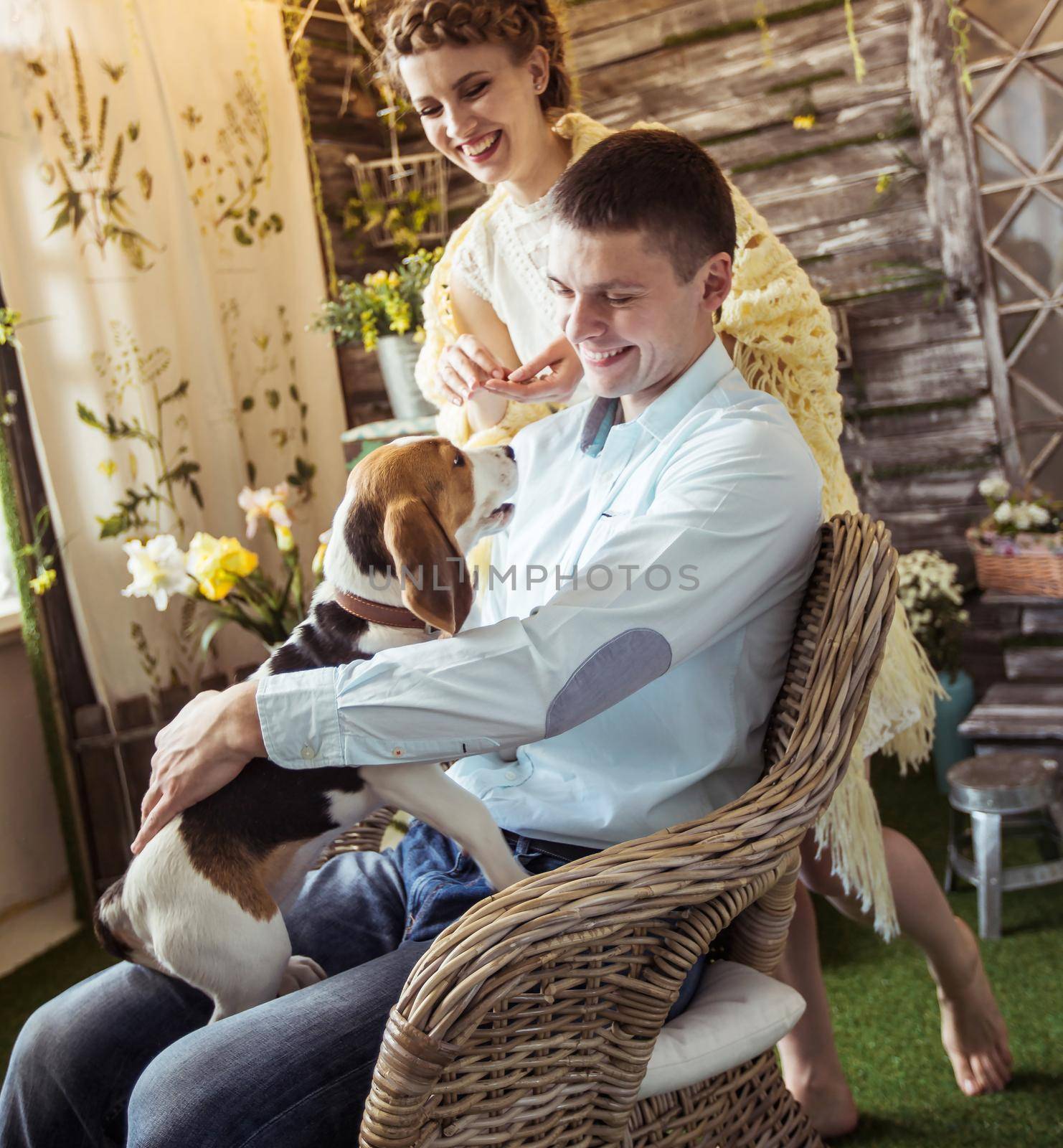 happy couple playing with his beloved dog in the living room