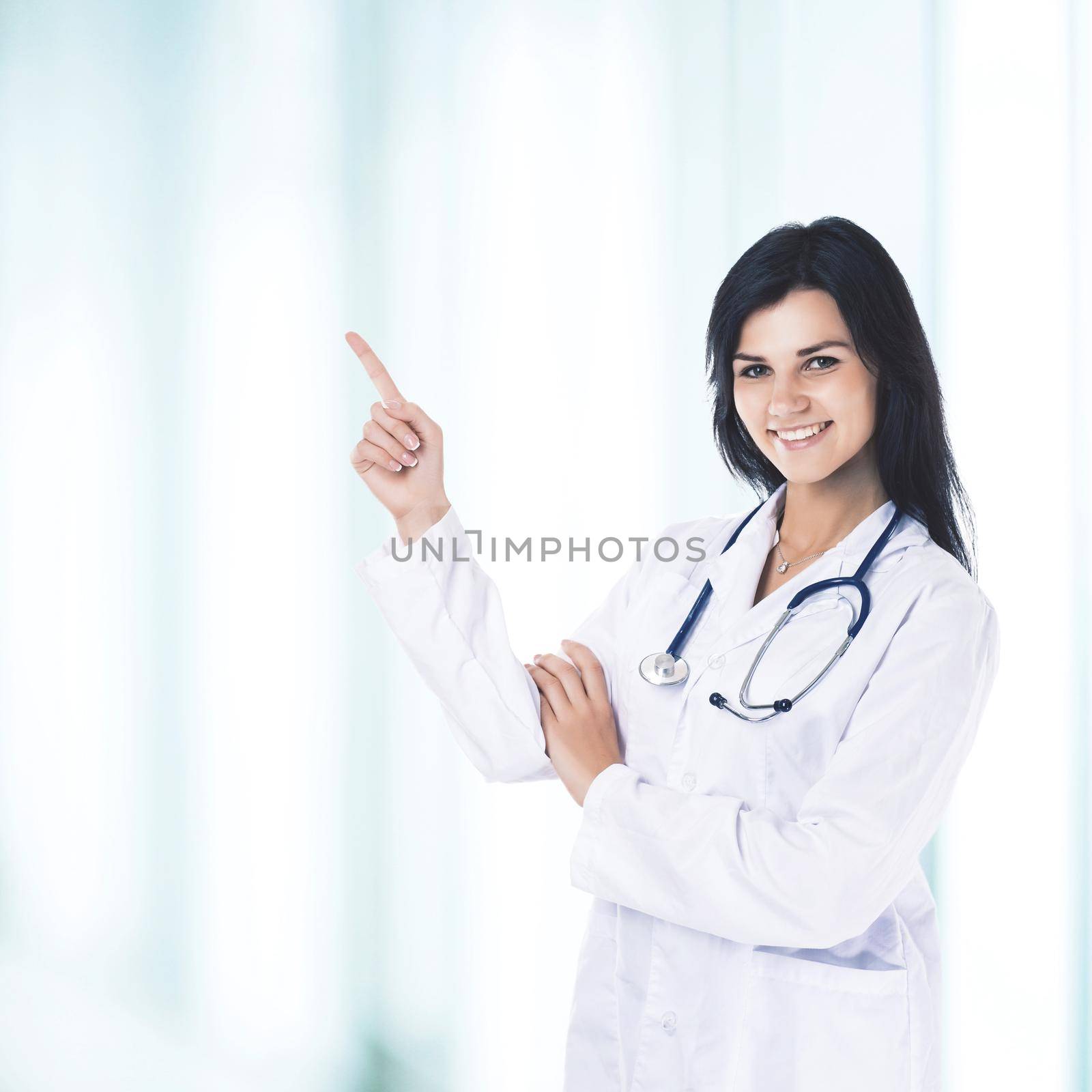 Young, handsome, friendly, smiling and experienced female doctor shows his hand to the side for your advertising text or products in the field of medicine