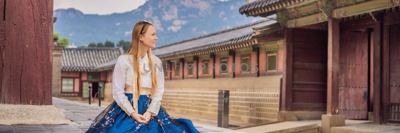 Young caucasian female tourist in hanbok national korean dress. Travel to Korea concept. National Korean clothing. Entertainment for tourists - trying on national Korean clothing BANNER, LONG FORMAT by galitskaya