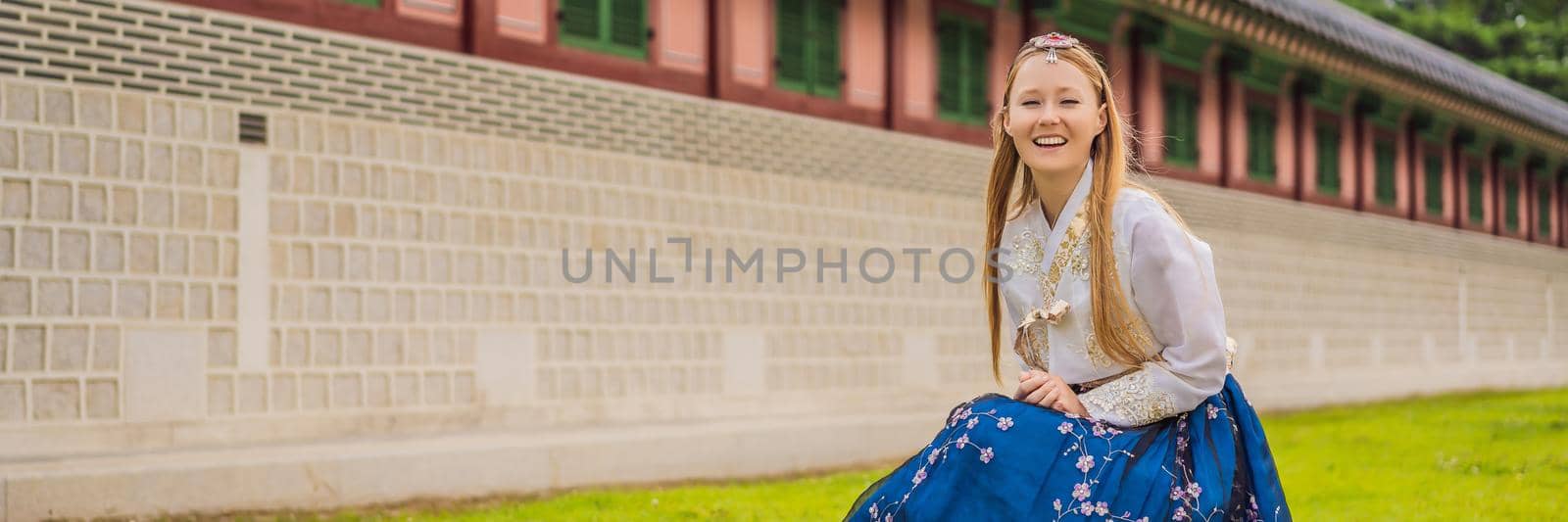 Young caucasian female tourist in hanbok national korean dress. Travel to Korea concept. National Korean clothing. Entertainment for tourists - trying on national Korean clothing BANNER, LONG FORMAT by galitskaya