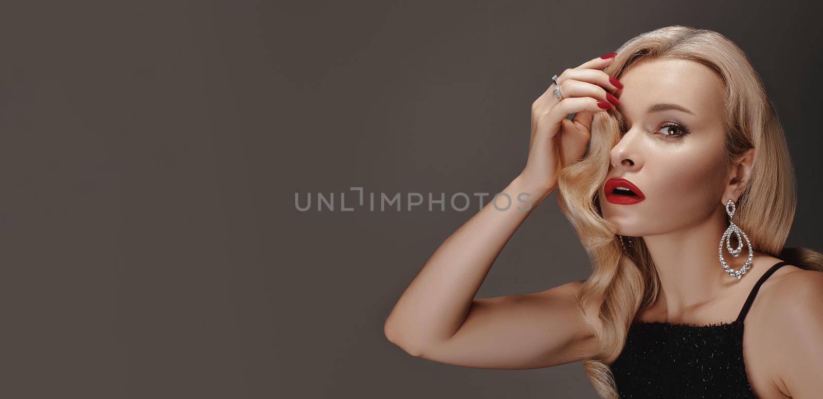 Beautiful Sexy Woman with Fashion Make-up and Blond Curly Wave Hairstyle, Bright Accessories. Glamour Pin-up Girl with Red lips. American Diva Style with Brilliant Earrings and Rings