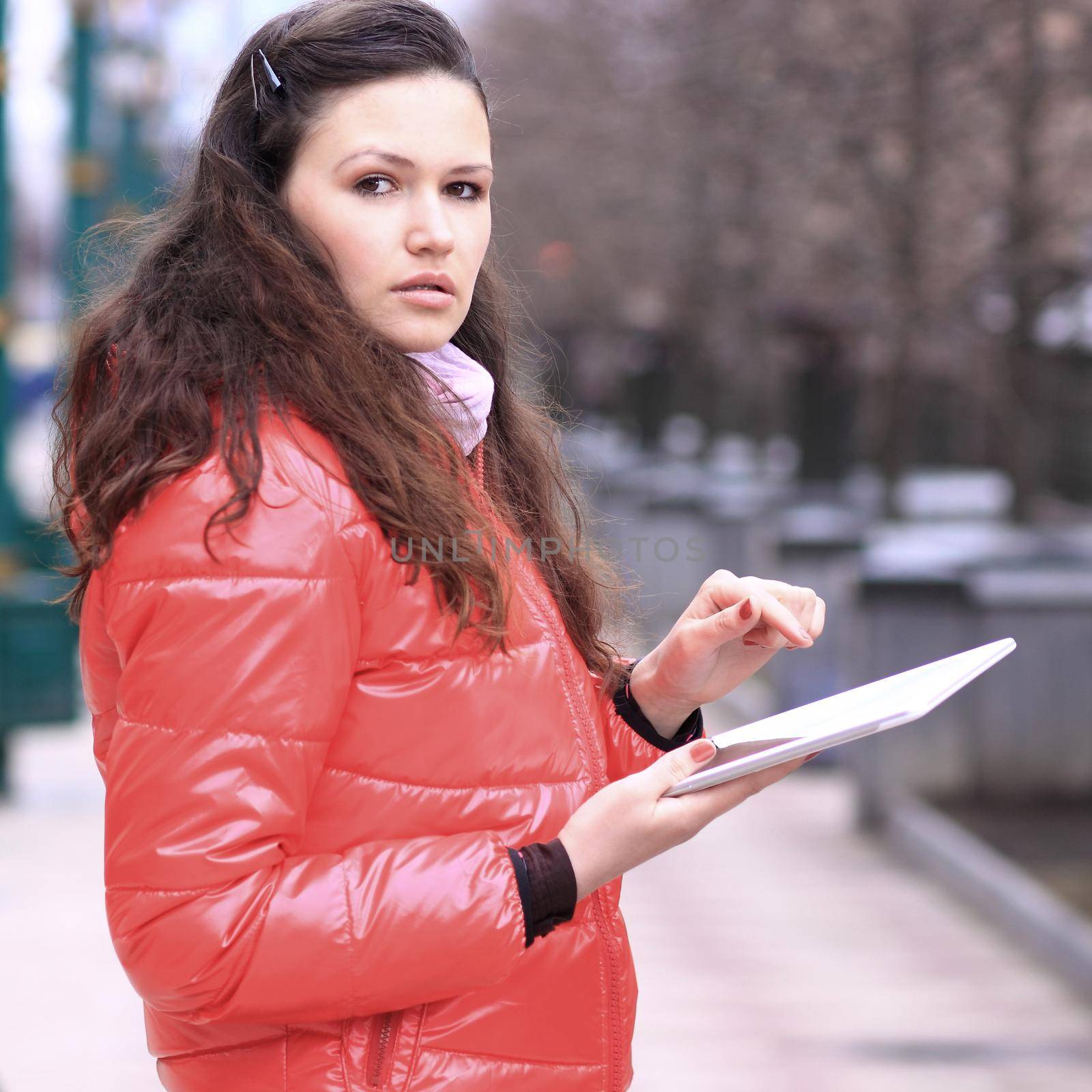 Beautiful girl with tablet in hands in the Park talking on social networks by SmartPhotoLab