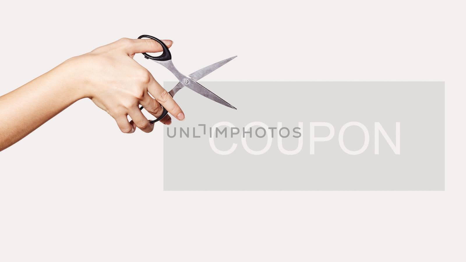 Female Hand is Holding Scissors. Copy Space for your Text. Isolated on White Background. Light Grey Coupon for Shopping Sales