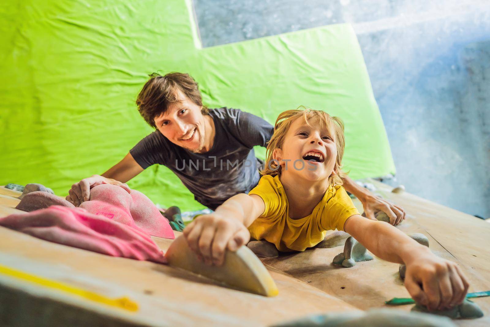 Dad and son at the climbing wall. Family sport, healthy lifestyle, happy family.