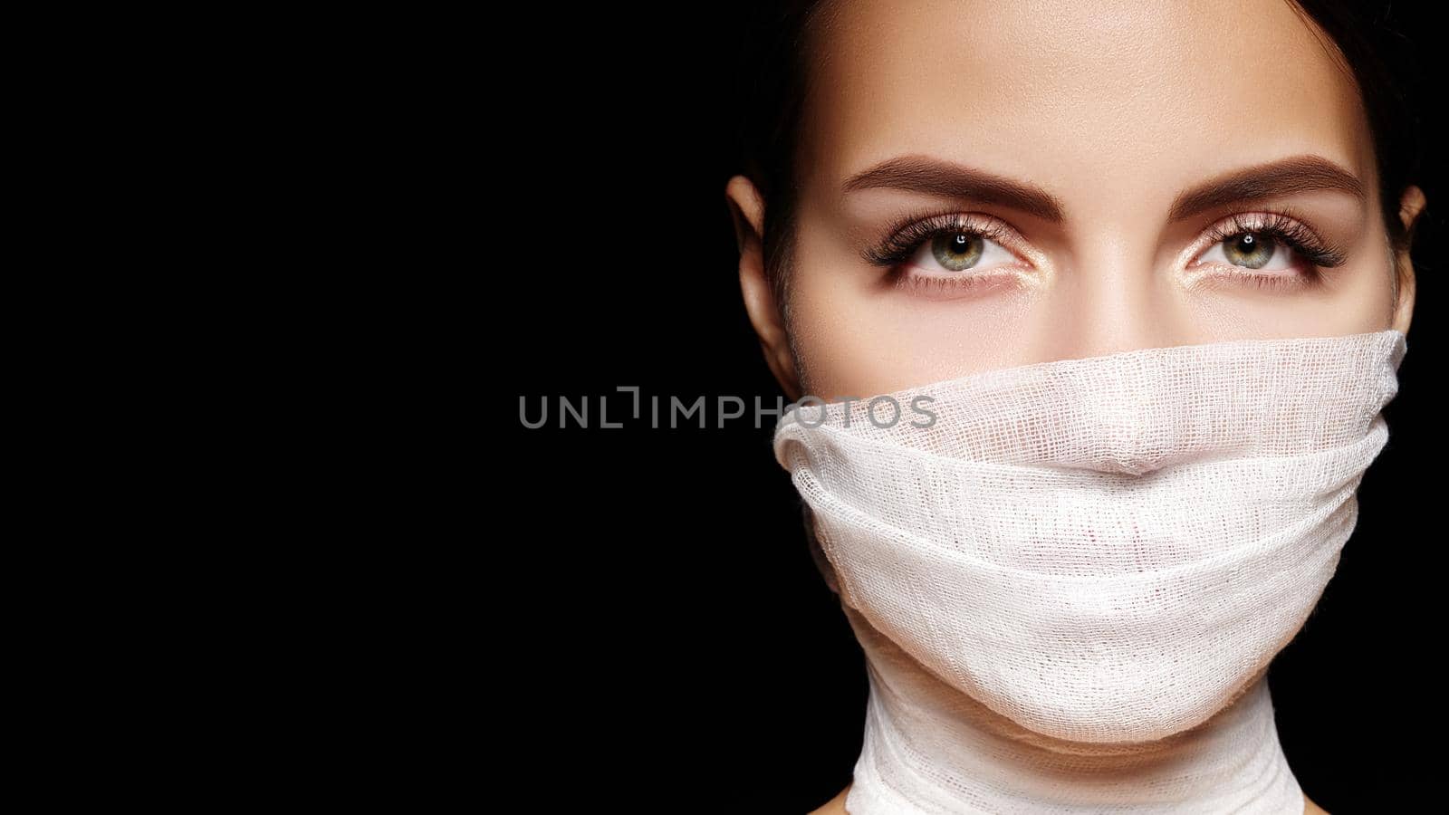 Beautiful woman with bandage mask on face. Fashion eye make-up. Beauty surgery or protection hygiene in virus pandemic by MarinaFrost