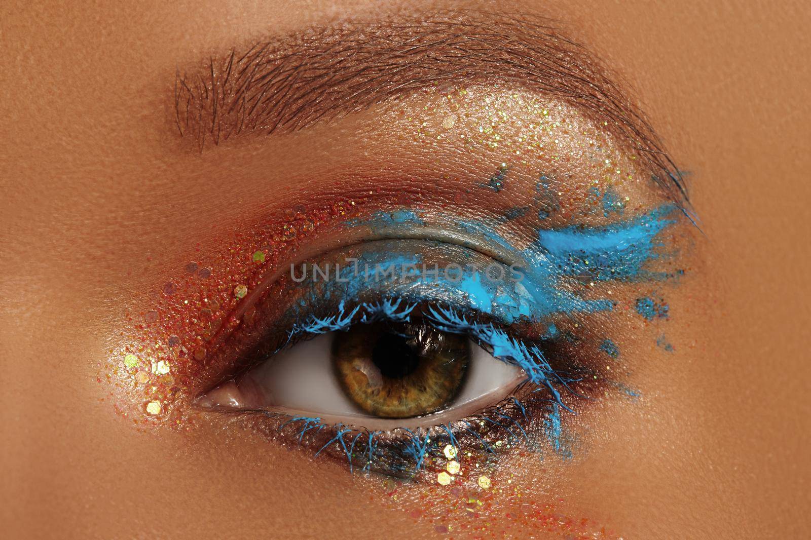Macro Close-up Creative Art Eye Make-up. Cream Texture Colorful design on female Eye Lid. Beautiful female eye with aquamarine paint and bronze pigment