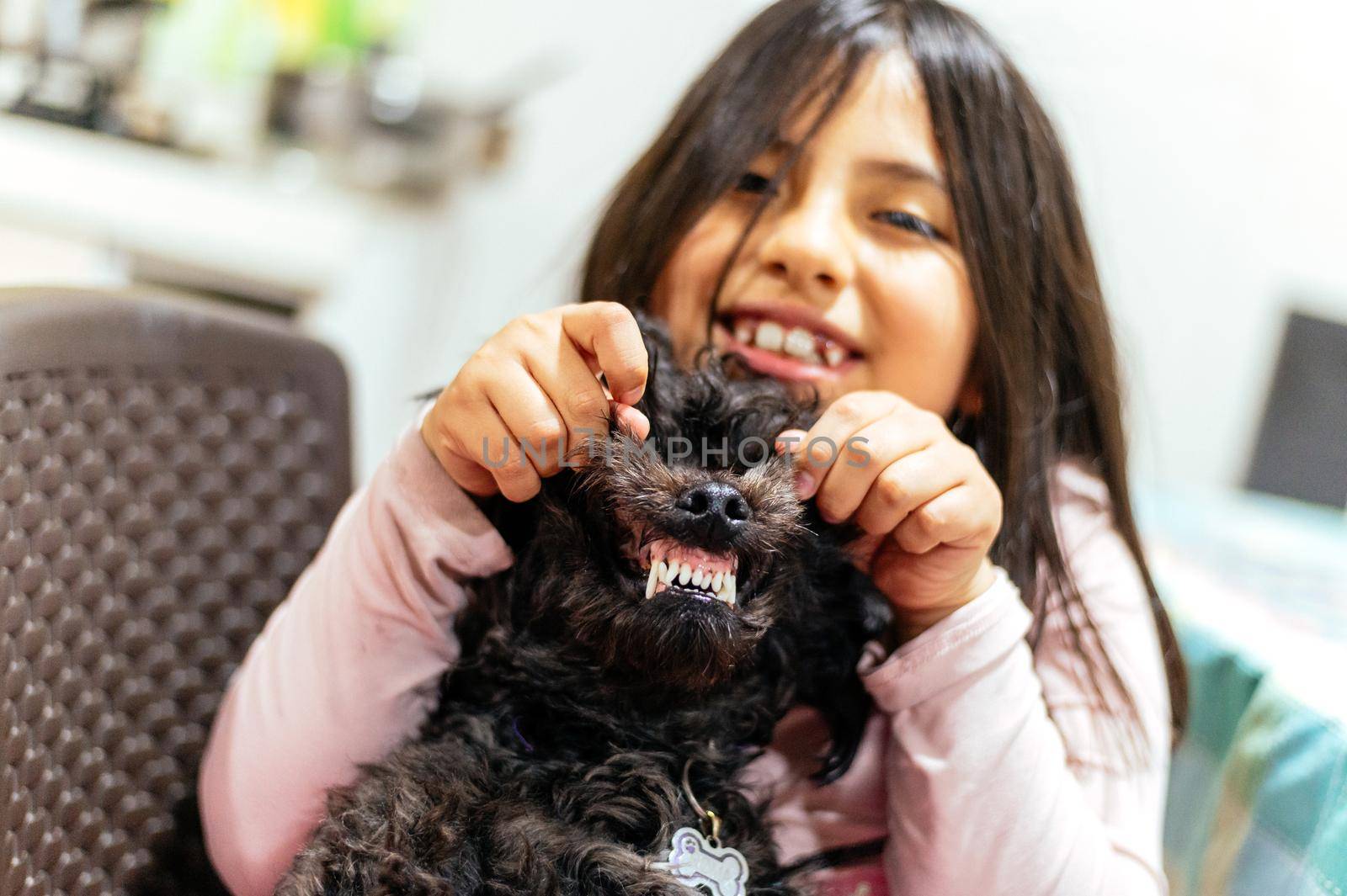 Adorable smiling little girl child schoolgirl holding and playing with pet dog. Best friends