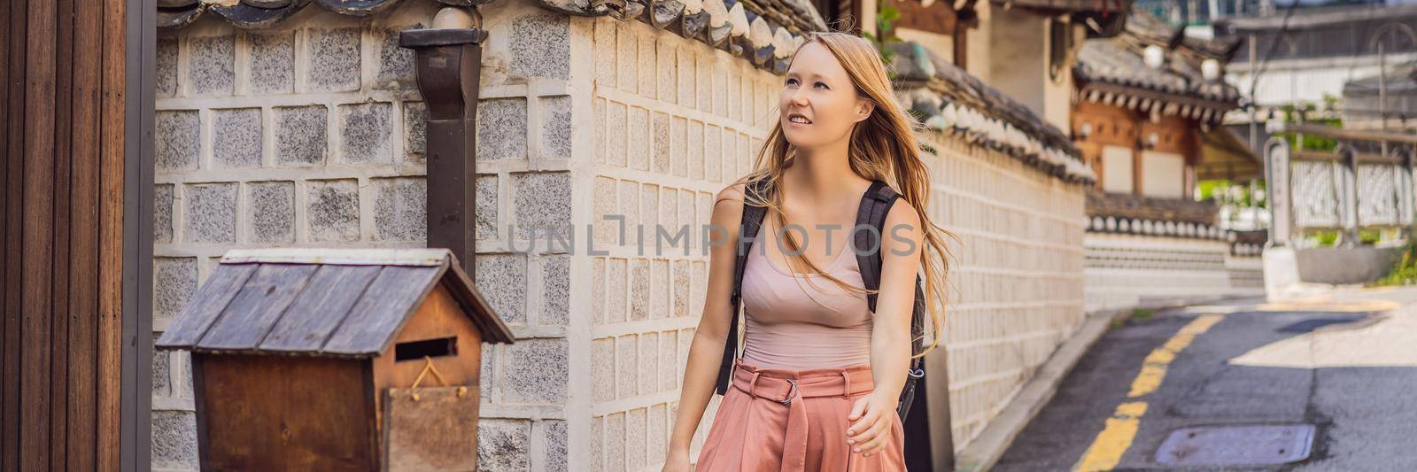 Young woman tourist in Bukchon Hanok Village is one of the famous place for Korean traditional houses have been preserved. Travel to Korea Concept. BANNER, LONG FORMAT