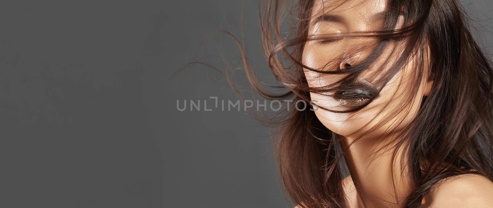 Fashion Model with Long Blowing Hair. Glamour Asian Beautiful Woman with Beautiful Brown Hair. Fashion Style. Copy space