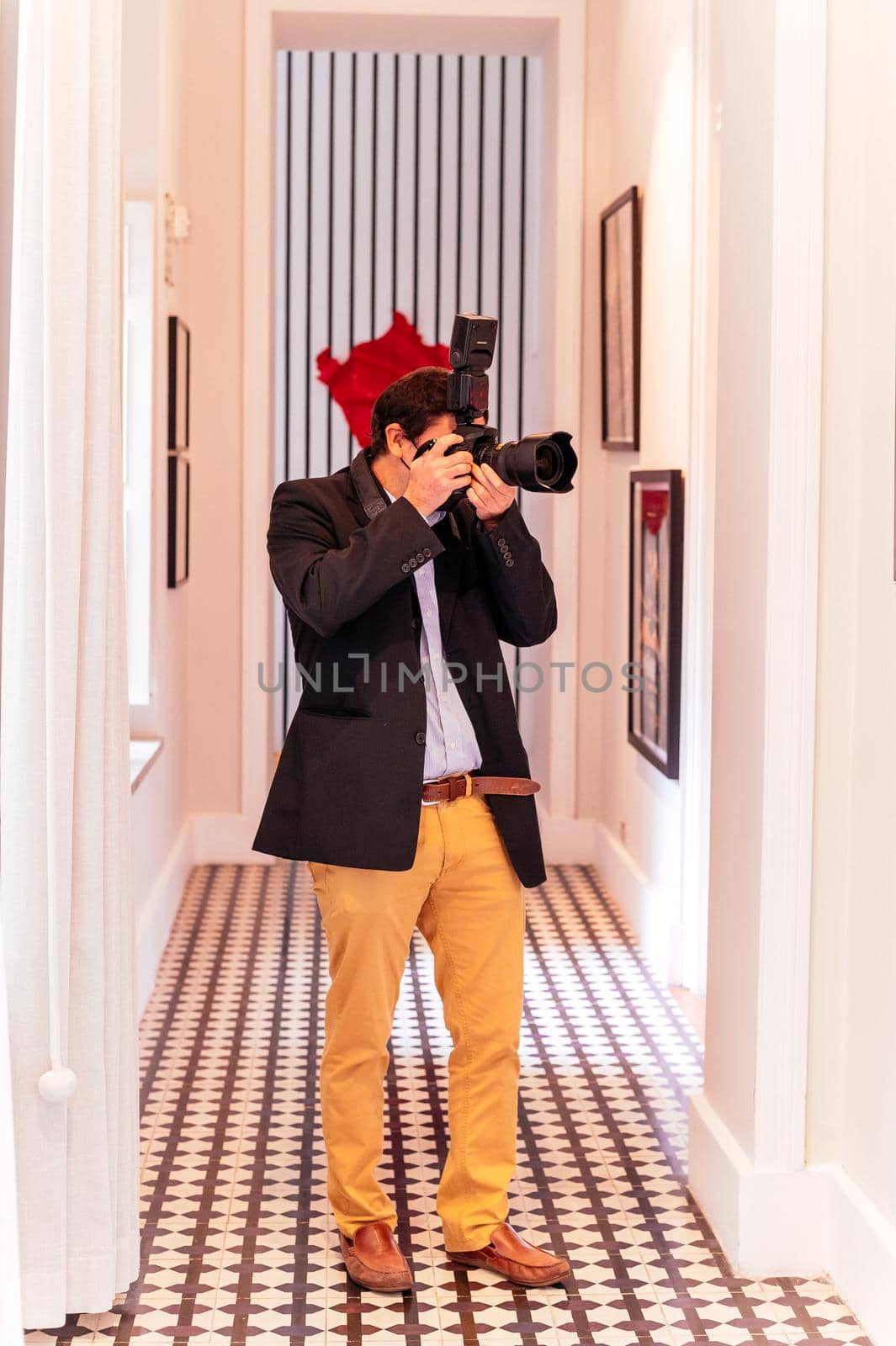 Young man taking photo with professional digital camera, focus on hand and lens. by Peruphotoart