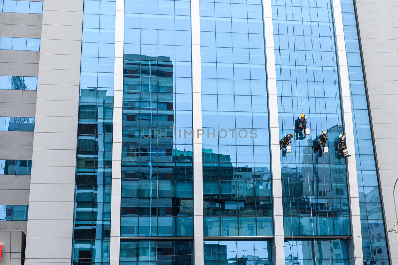 group of workers cleaning windows service on high rise building