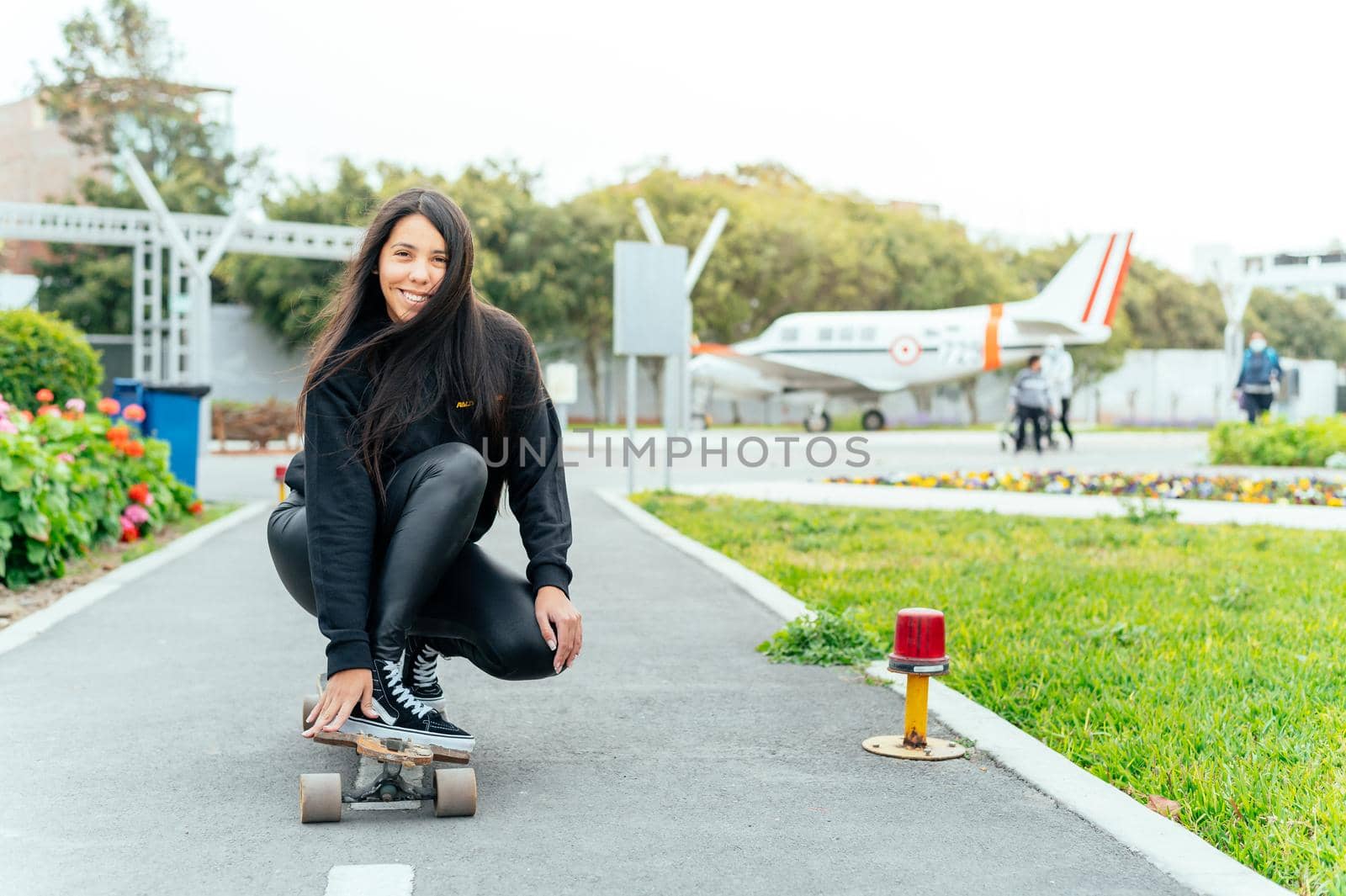 Young girl on longboard smiling. Outdoors, lifestyle