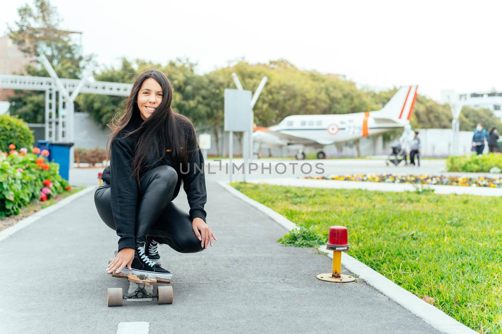 Young girl on longboard smiling. Outdoors, lifestyle