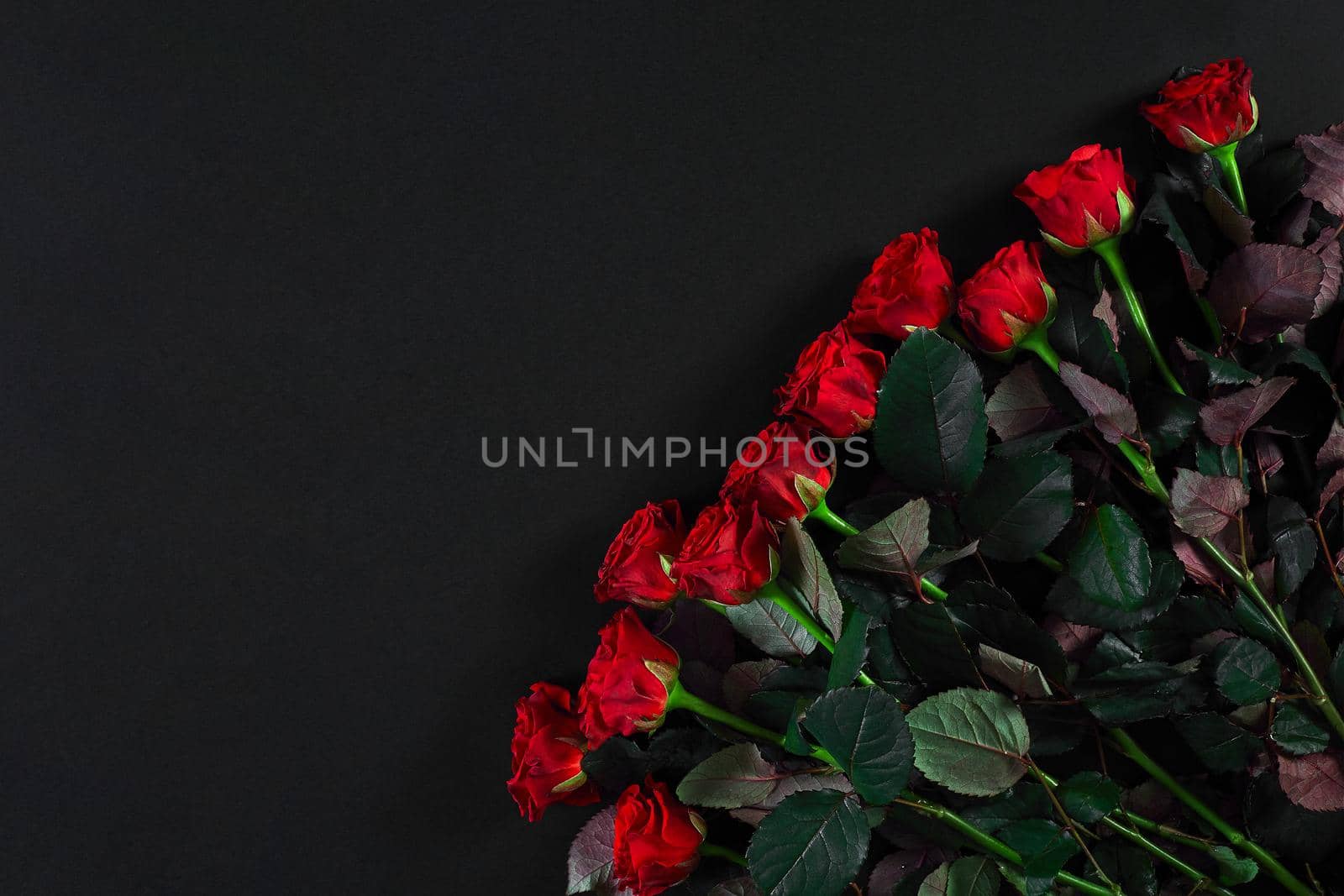 Bouquet of red roses on a black background. Top view. Flat lay. Copy space. Still life Valentine's Day