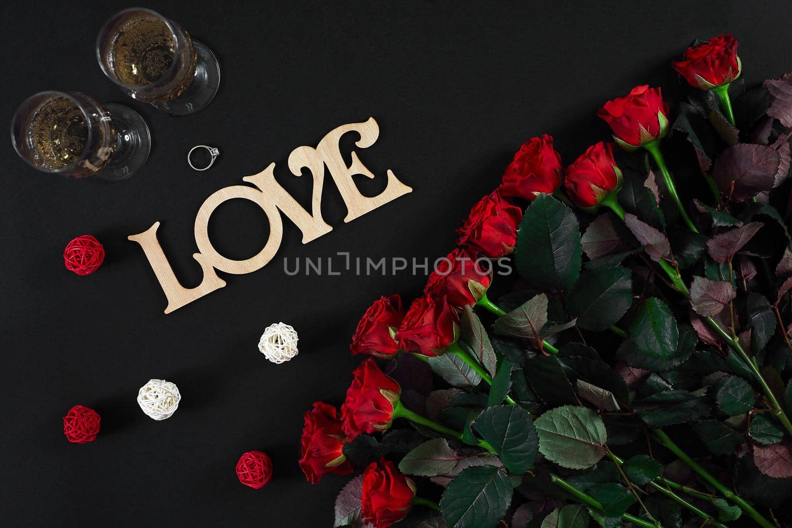 Bouquet of red roses and two glasses of champagne on a black bac by nazarovsergey