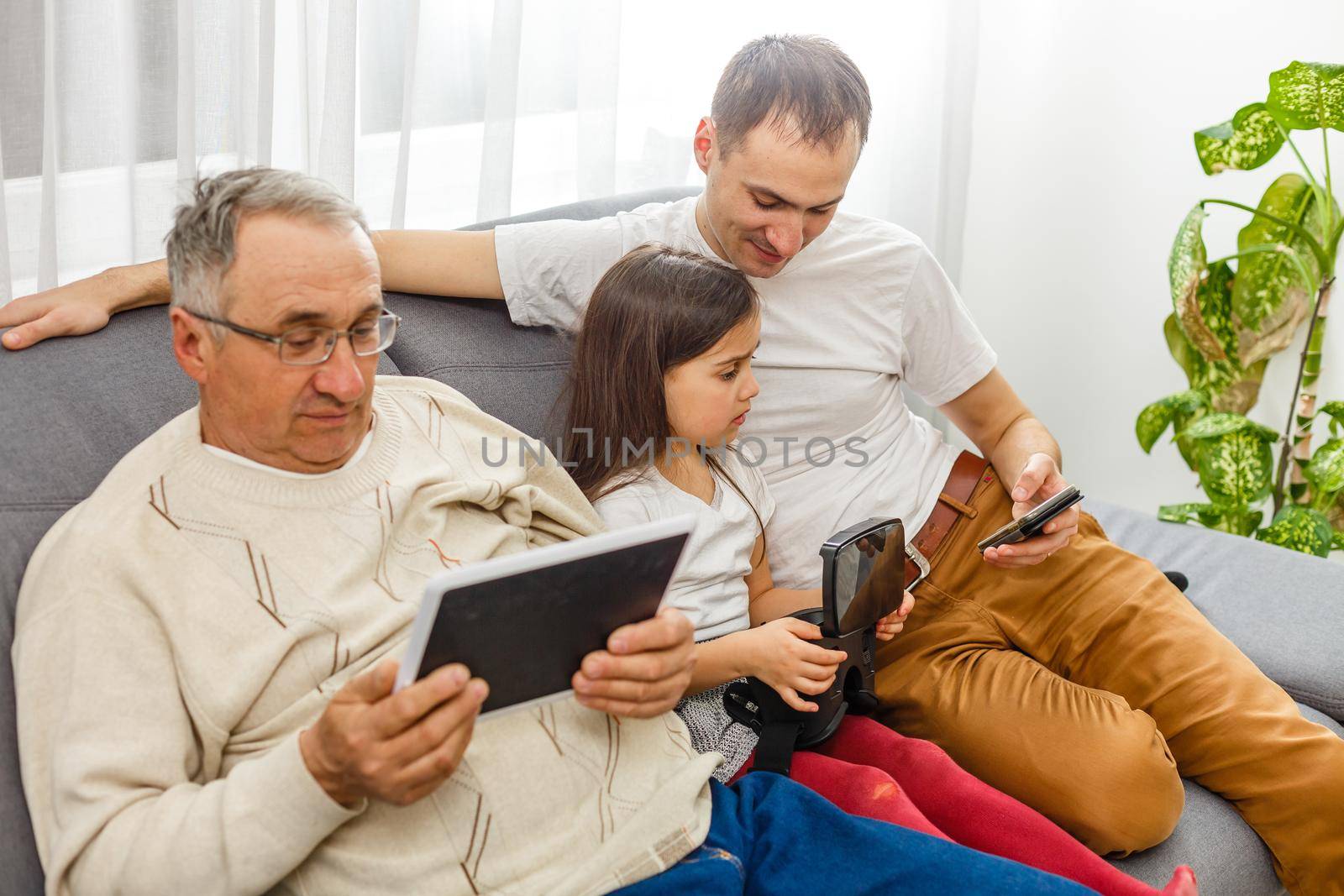 Big happy multigenerational family father, senior grandparents with cute little girl granddaughter at home. Family and love concept.