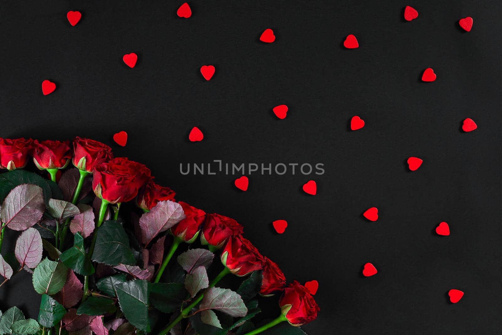 Bouquet of red roses on a black background. Top view. Flat lay. Copy space. Still life. Valentines day greeting card.