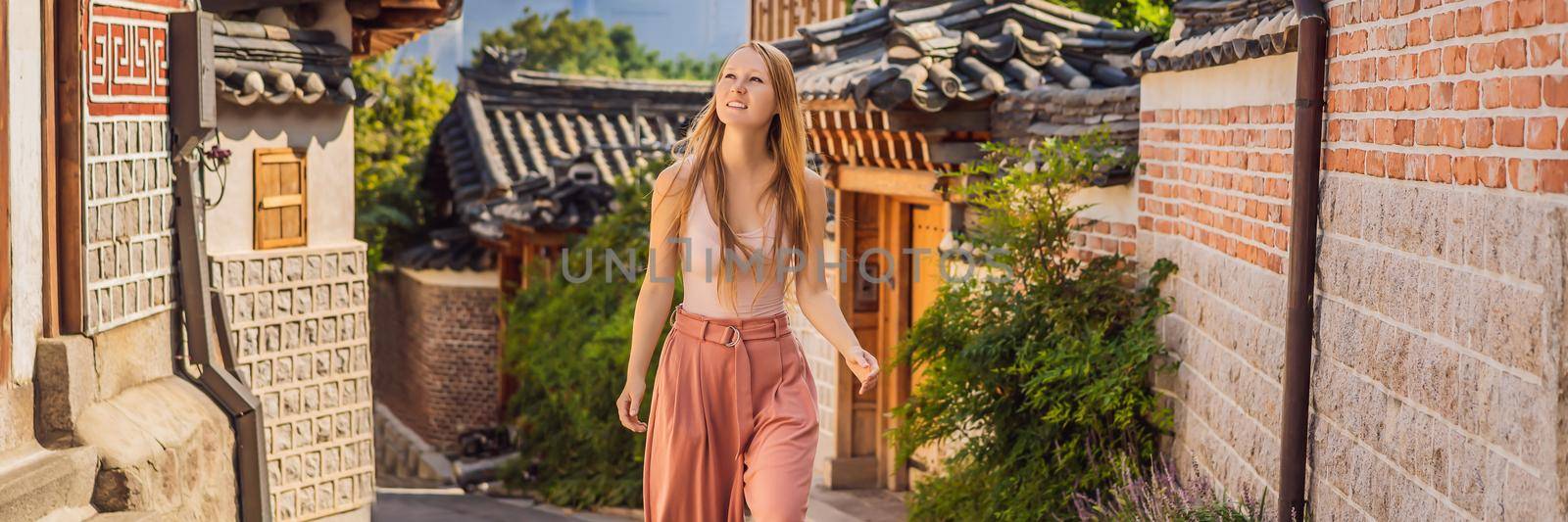 Young woman tourist in Bukchon Hanok Village is one of the famous place for Korean traditional houses have been preserved. Travel to Korea Concept BANNER, LONG FORMAT by galitskaya