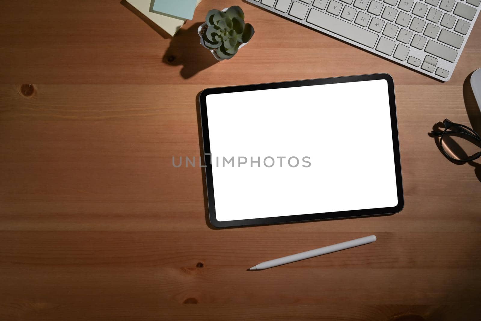 Wooden table with digital tablet and office supplies. Top view, office workplace with text space. by prathanchorruangsak