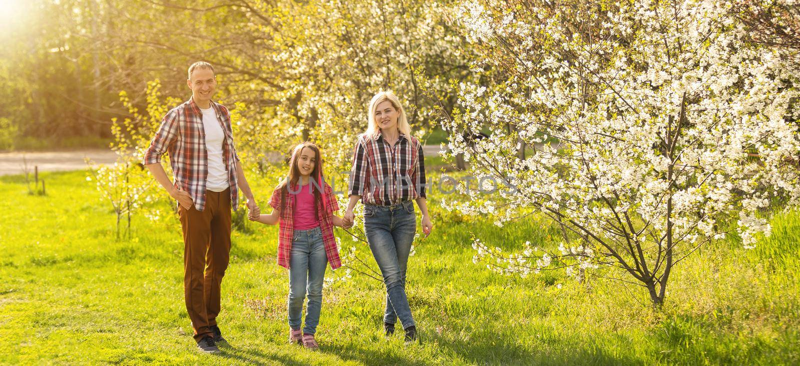 Happy family spending good time together in spring in a flowering garden.