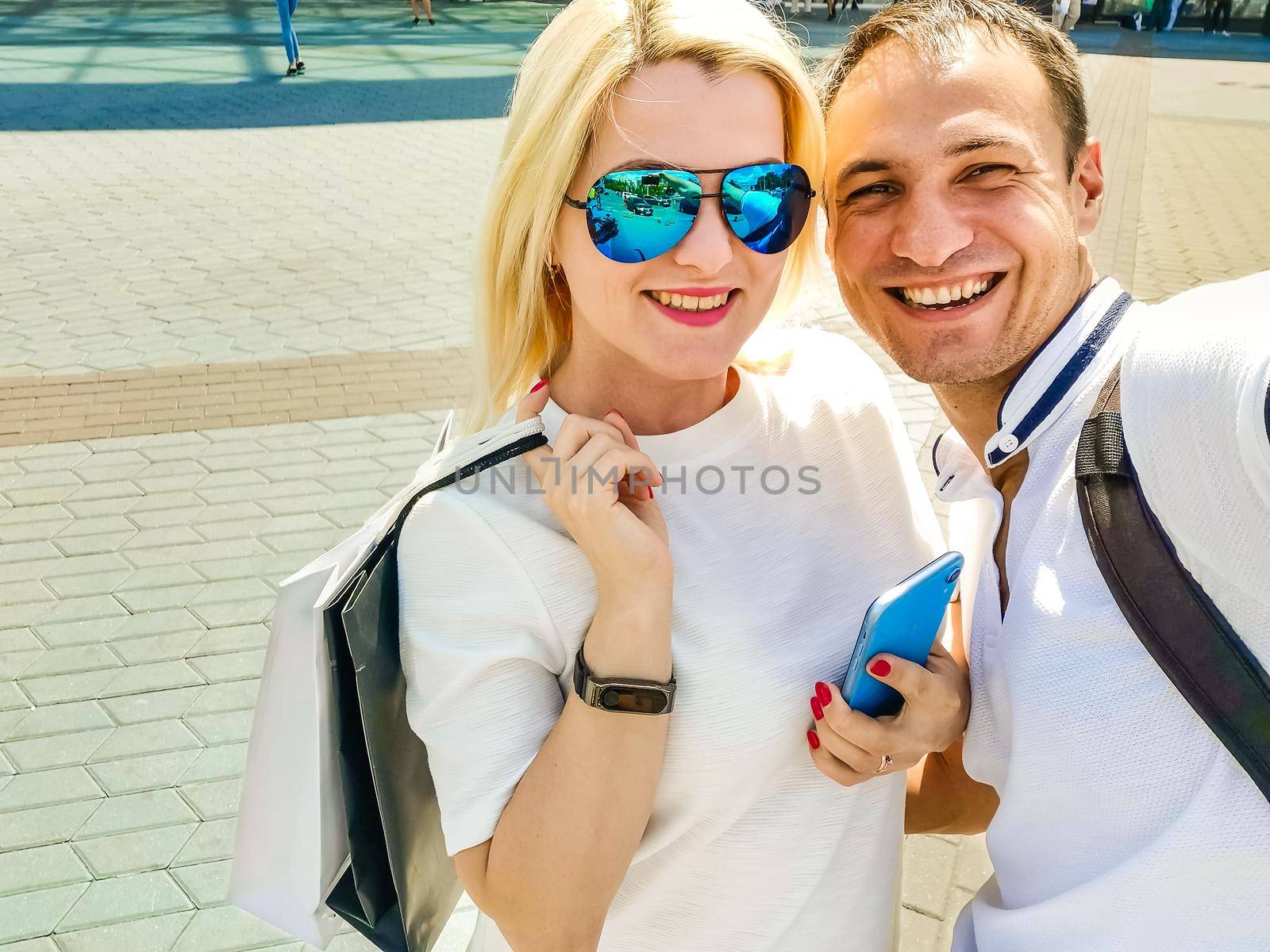 summer holidays, technology, love, relationship and dating concept - smiling couple taking selfie with smartphone in the city.