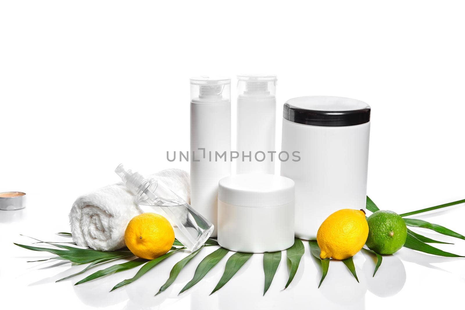 White bottles and two whole lemon and lime isolated on white background. The concept for advertising cosmetics. Still life. Copy space
