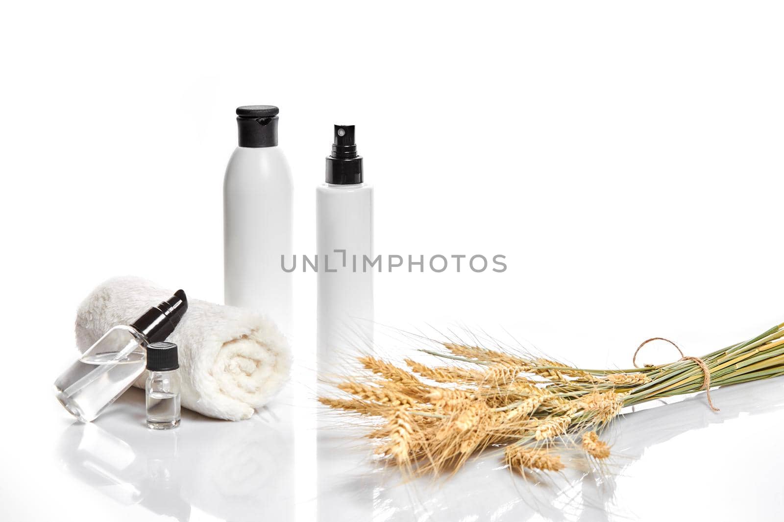 Herbal and mineral skincare. Jar of cream, oil with wheat, white cosmetic bottles. Without label. The concept for advertising cosmetics. Still life. Copy space