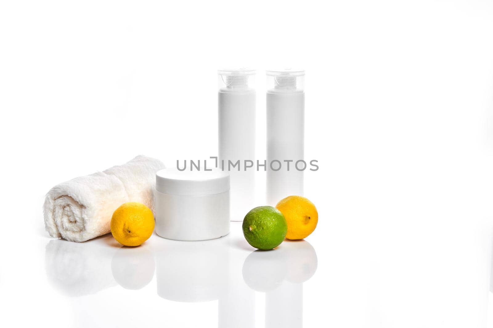 White bottles and two whole lemon and lime isolated on white background. The concept for advertising cosmetics by nazarovsergey