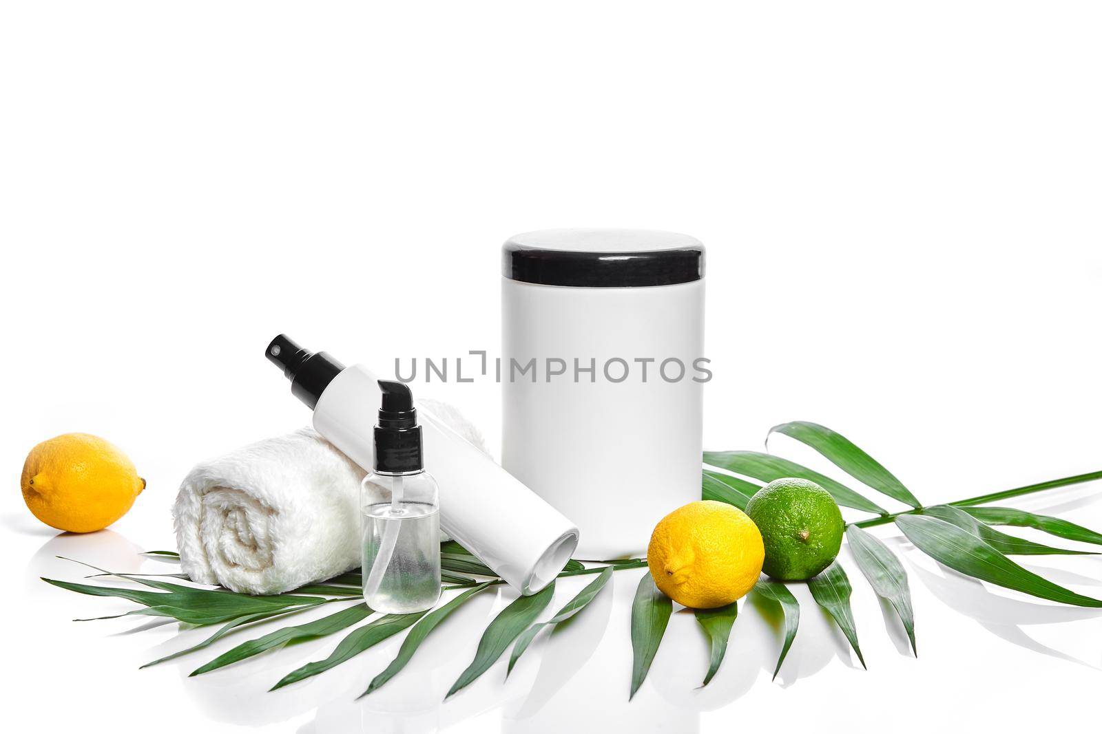White bottles and two whole lemon and lime isolated on white background. The concept for advertising cosmetics. Still life. Copy space
