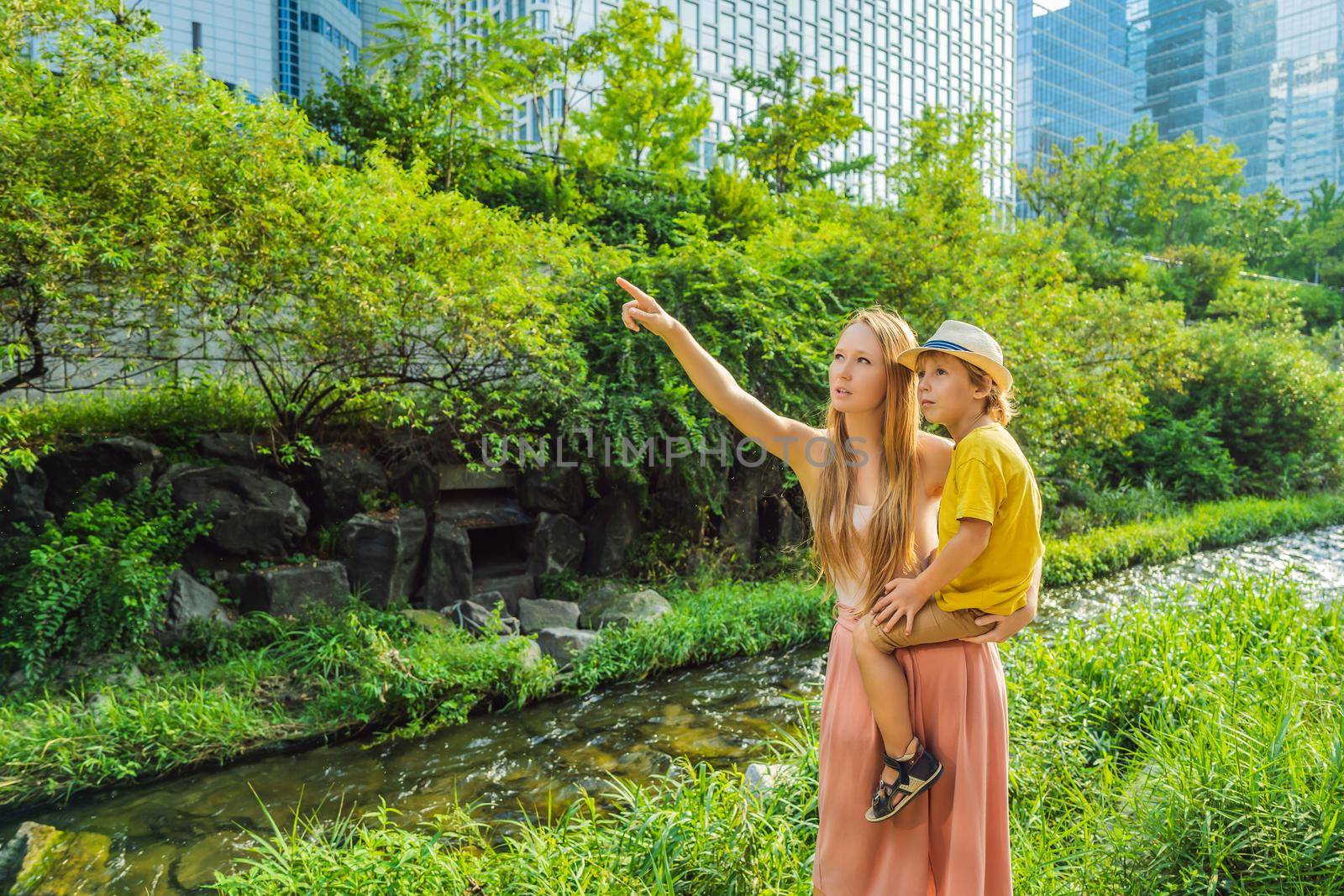 Mom and son tourists in Cheonggyecheon stream in Seoul, Korea. Cheonggyecheon stream is the result of a massive urban renewal project. Travel to Korea Concept.