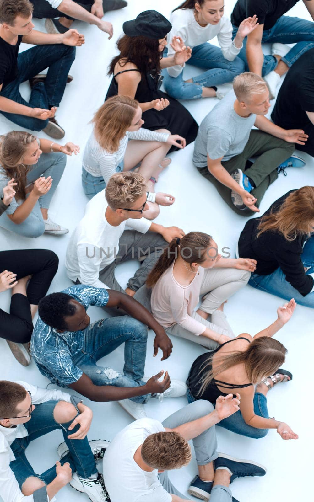 casual group of young people meditating sitting on the floor. by asdf