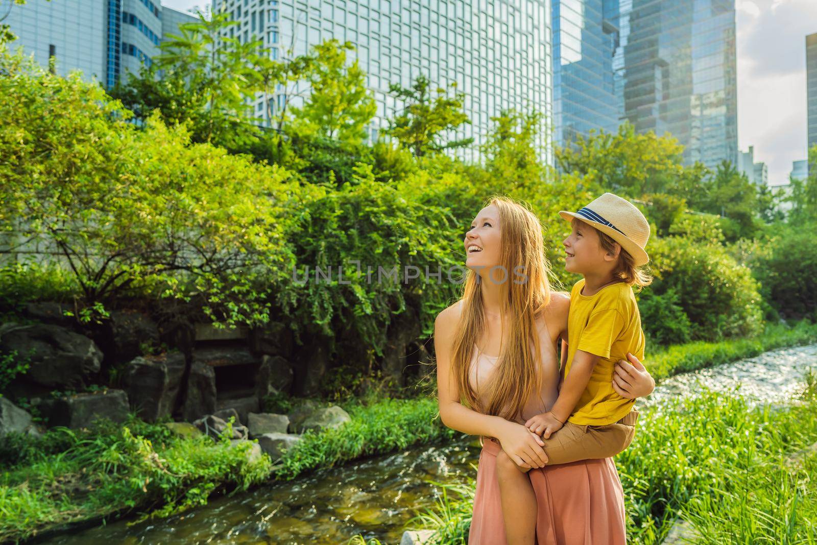 Mom and son tourists in Cheonggyecheon stream in Seoul, Korea. Cheonggyecheon stream is the result of a massive urban renewal project. Travel to Korea Concept by galitskaya