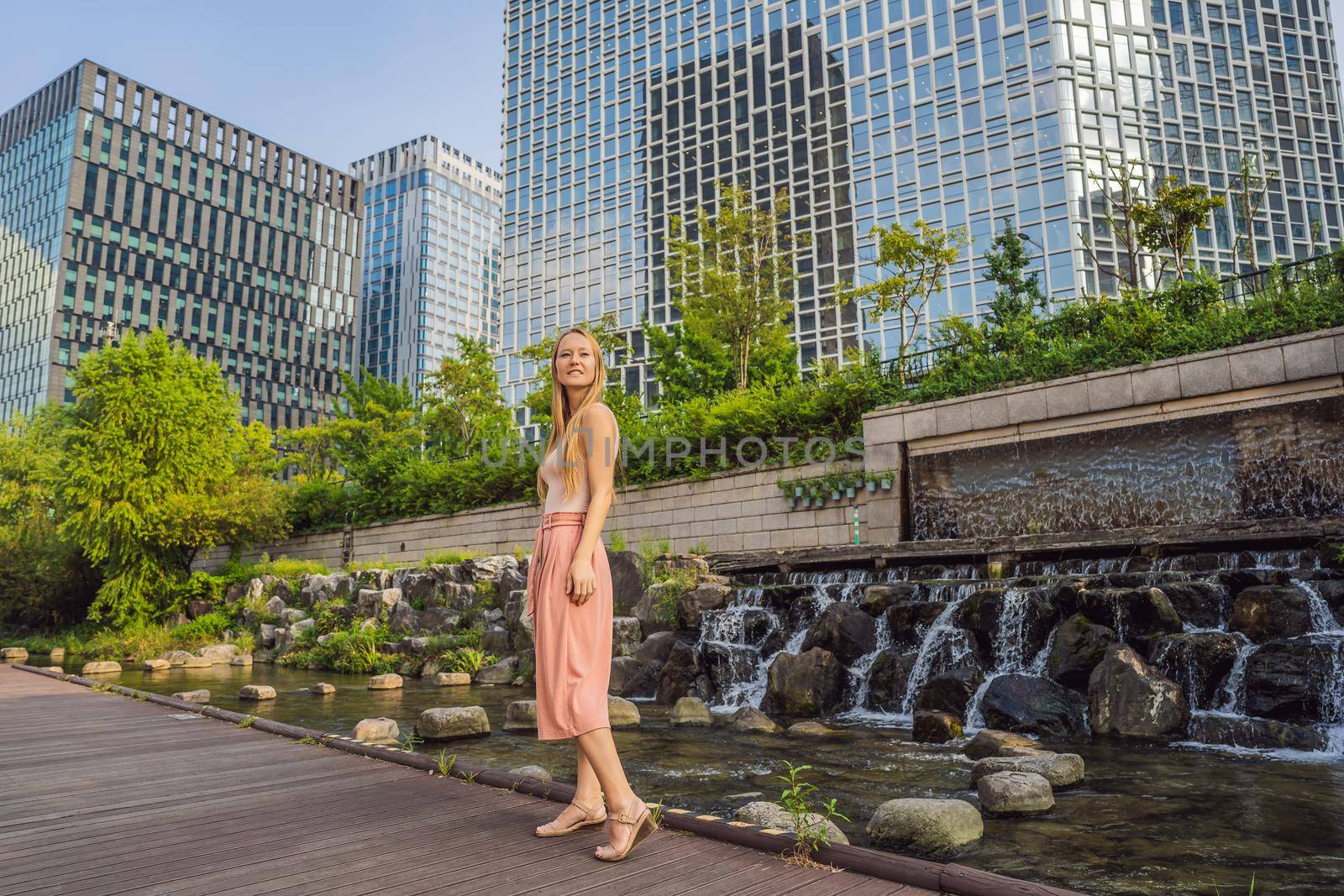 Young woman tourist in Cheonggyecheon stream in Seoul, Korea. Cheonggyecheon stream is the result of a massive urban renewal project. Travel to Korea Concept.