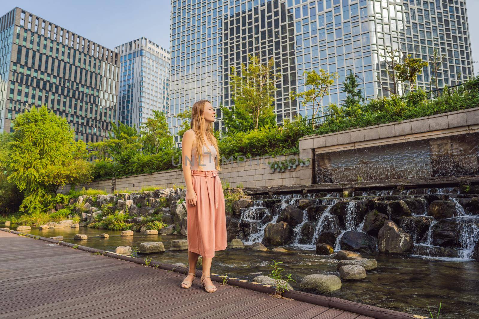 Young woman tourist in Cheonggyecheon stream in Seoul, Korea. Cheonggyecheon stream is the result of a massive urban renewal project. Travel to Korea Concept by galitskaya