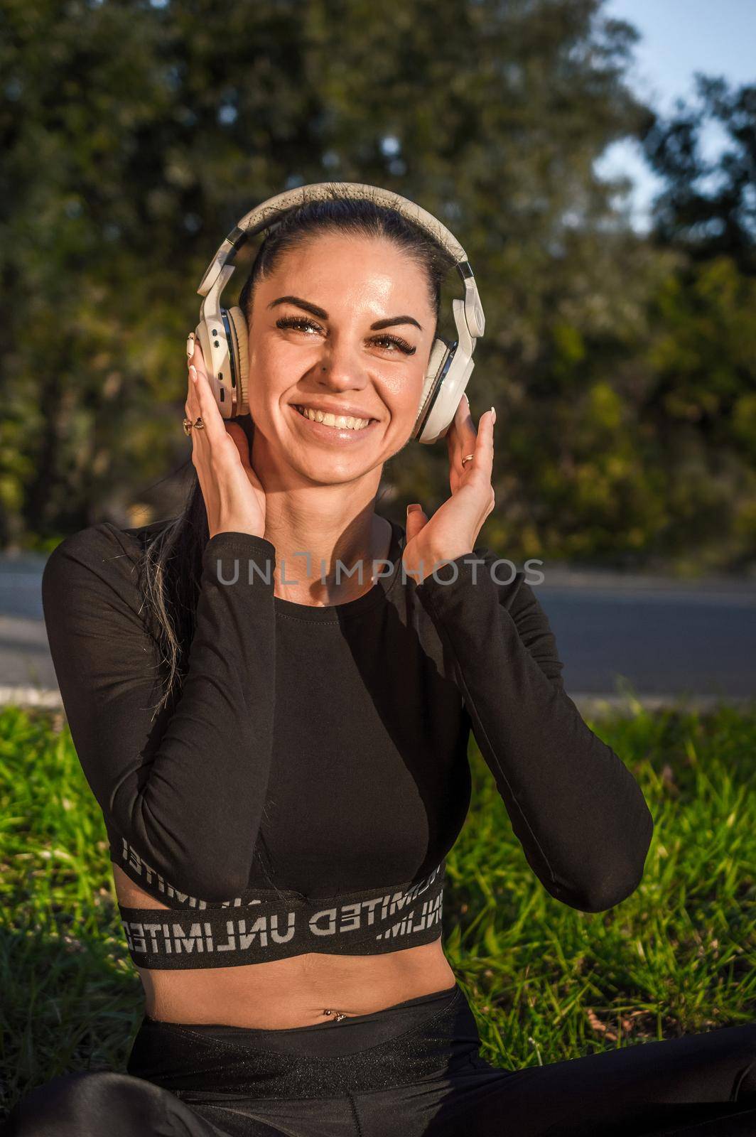 Cute sporty girl listening to music with headphones by Proff
