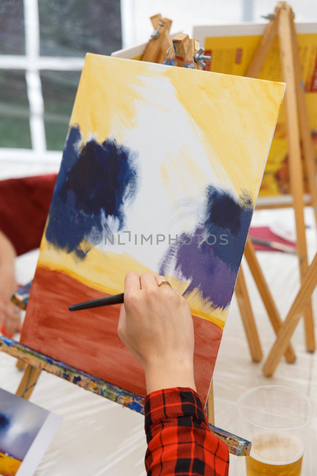Closeup of female artist hand paint a picture on a palette by BY-_-BY
