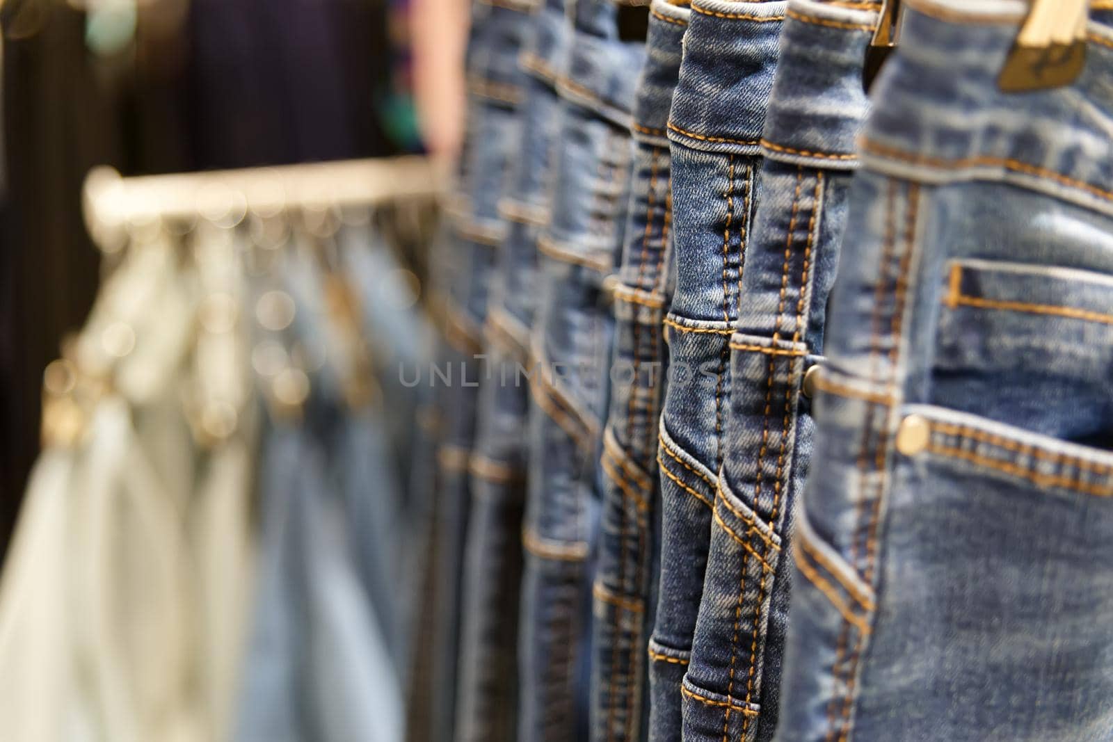 Set of blue jeans hanging on hangers in shop