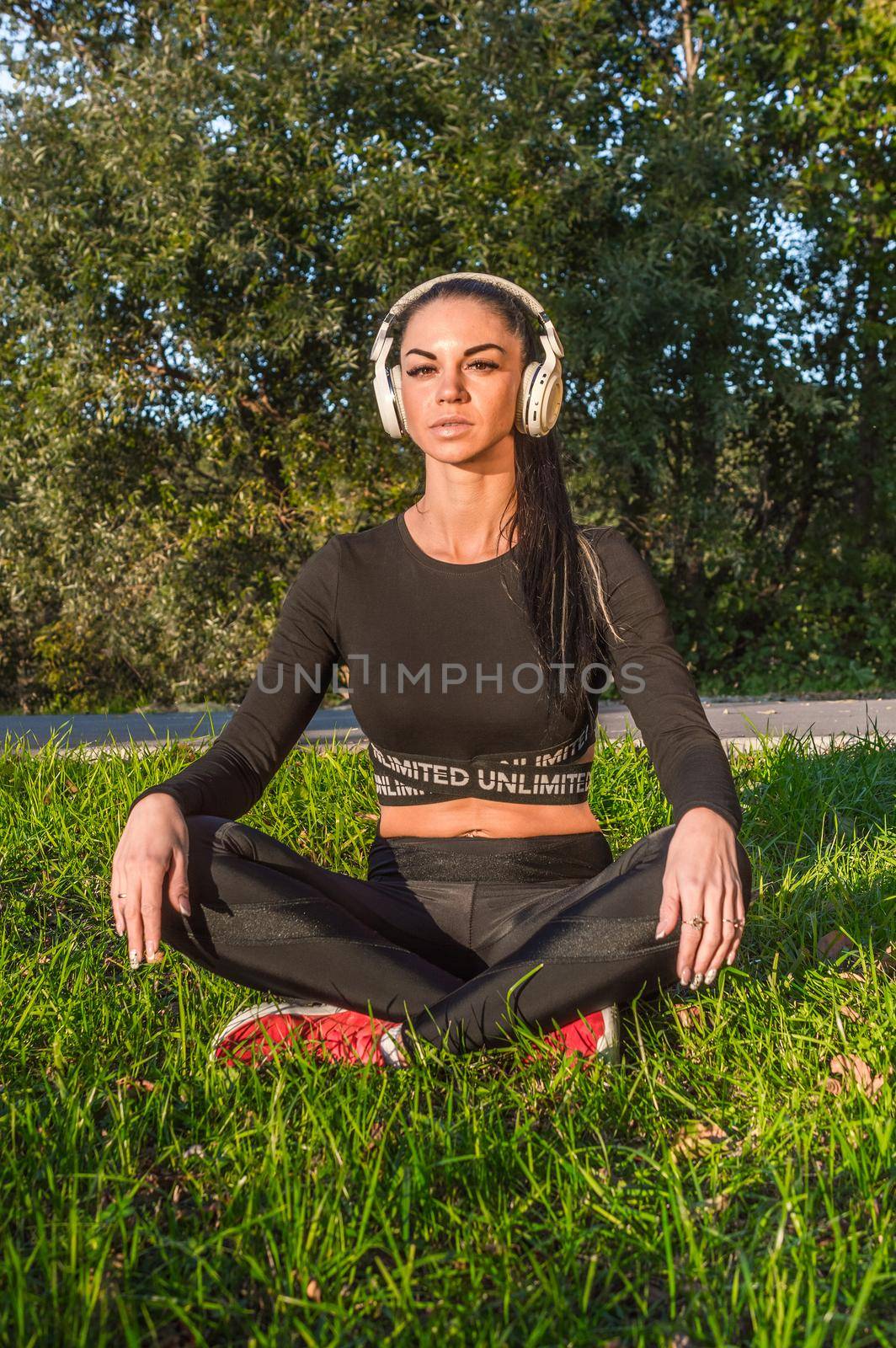 Sportswoman outdoors with headphones by Proff