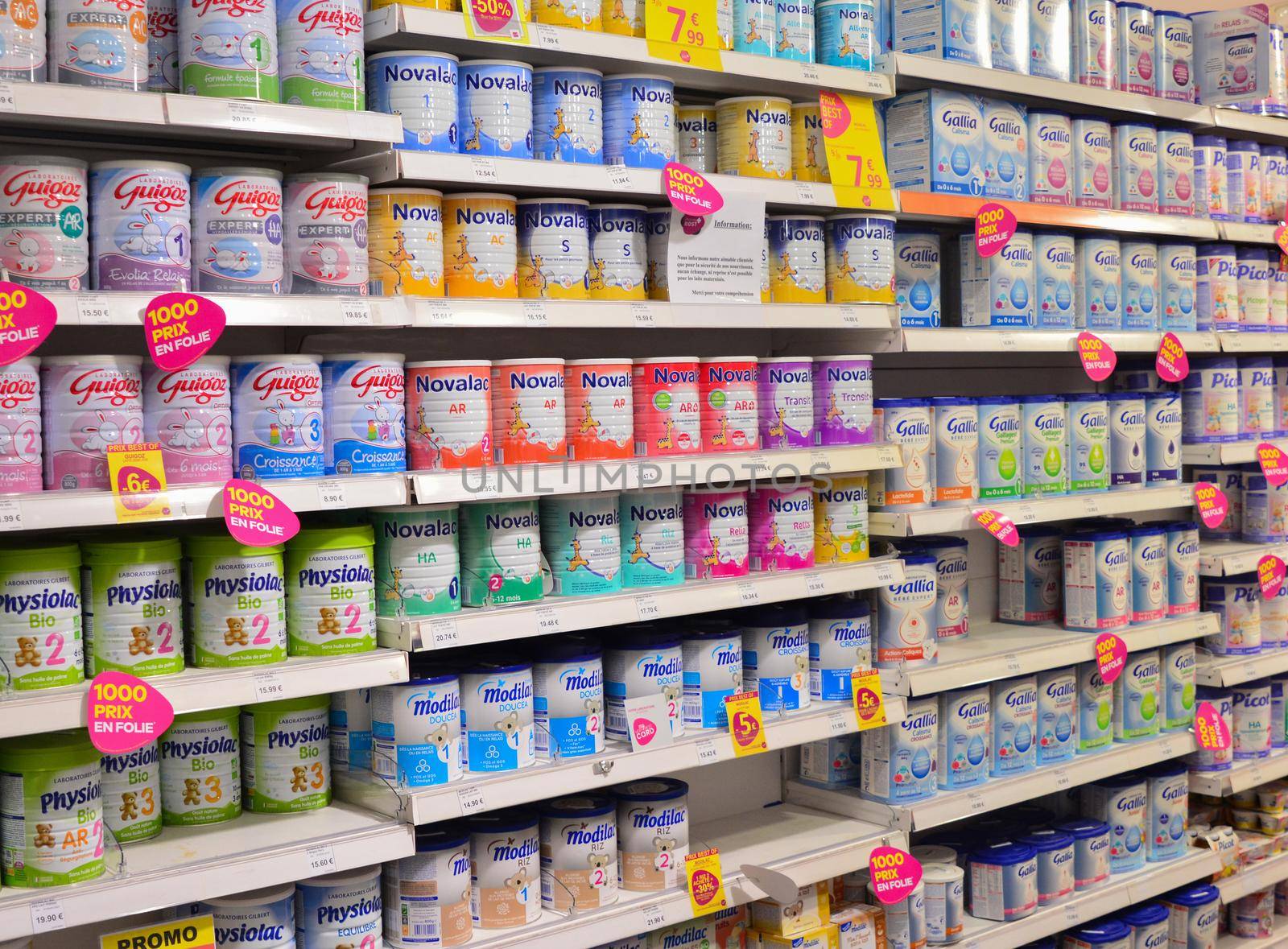 LE MANS, FRANCE - OCTOBER 12, 2017: Row of variety of artificial milk for a child on the counter of a supermarket. Powdered Baby Milk Formula