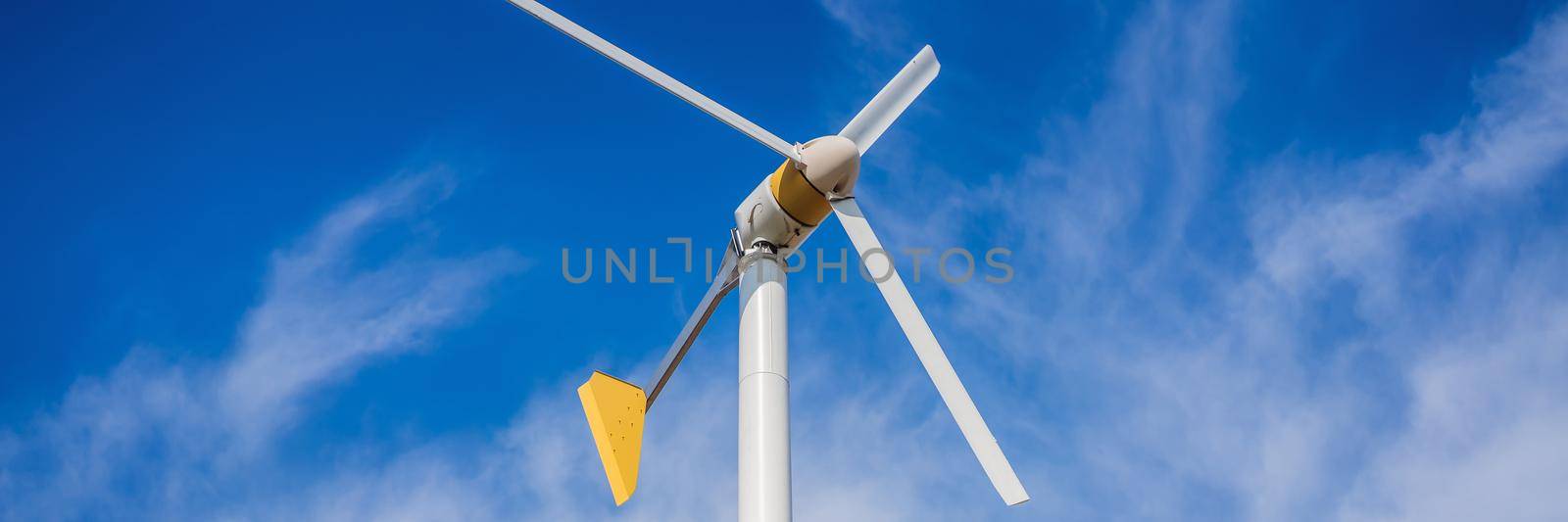 Wind turbines generating electricity with blue sky - energy conservation concept. BANNER, LONG FORMAT