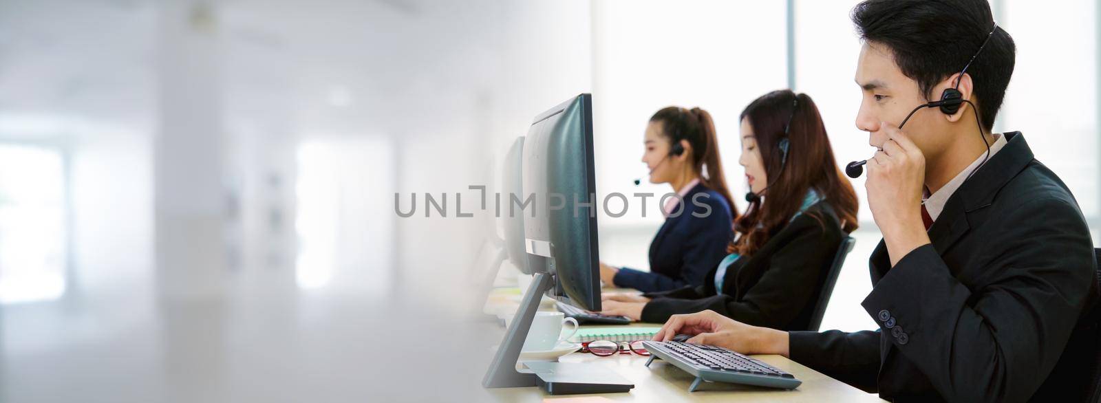 Business people wearing headset working in office in widen view by biancoblue