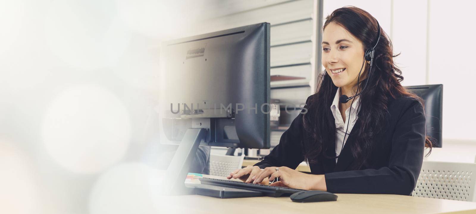 Business people wearing headset working in office to support remote customer or colleague. Call center, telemarketing, customer support agent provide service in broaden view .