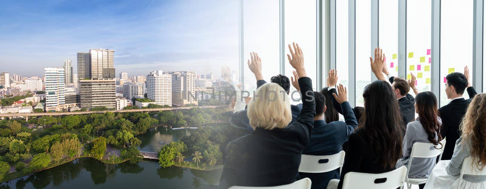 Group of business people meeting in a seminar conference widen view . Audience listening to instructor in employee education training session . Office worker community summit forum with speaker .