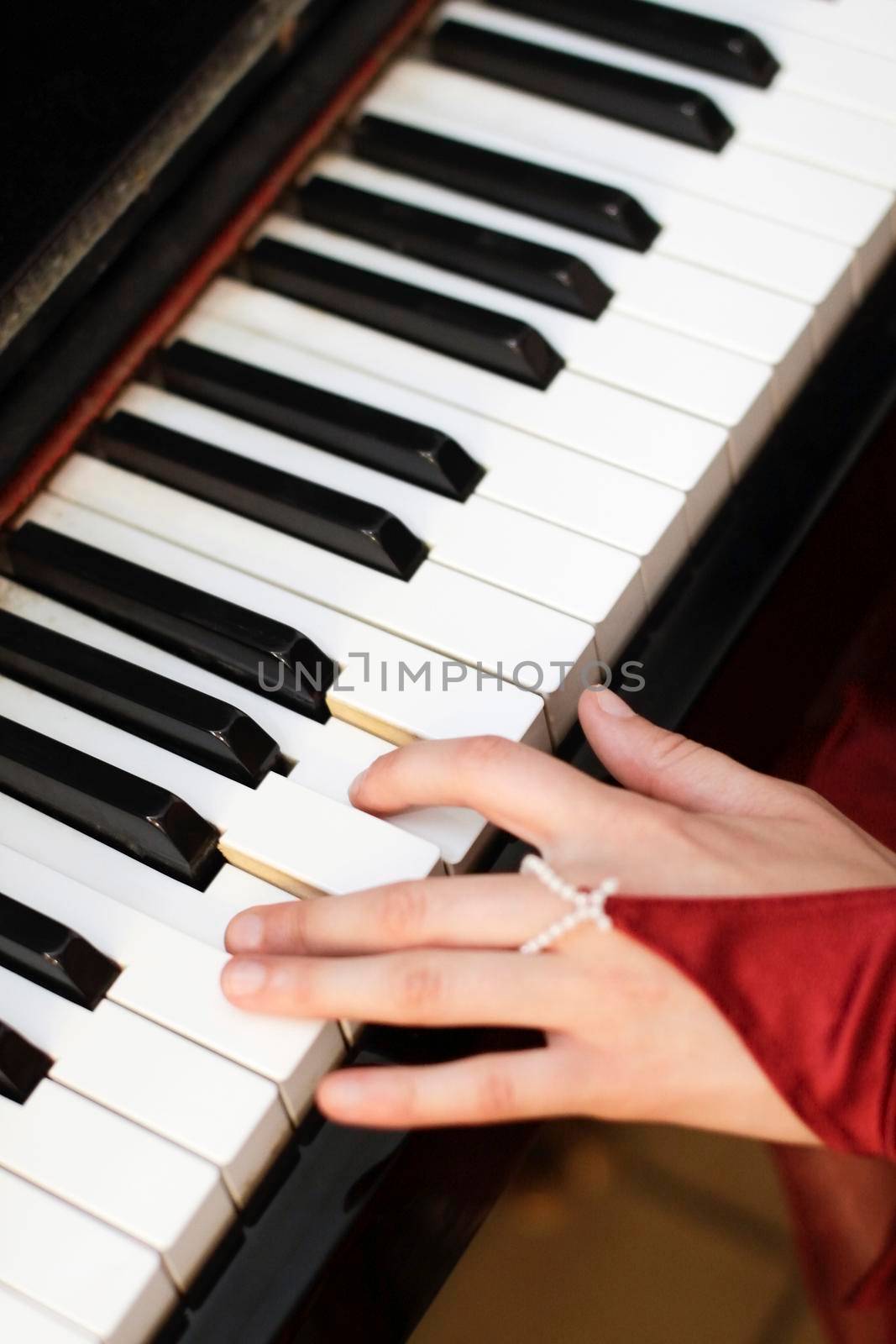 Old piano keyboard with woman's hand playing
