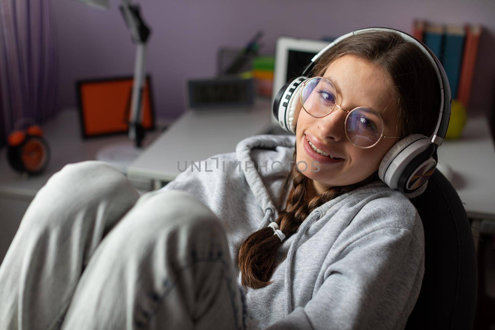 Young brunette full of joy while listening to music on wireless headphones. Music emotion gives happiness and smile.