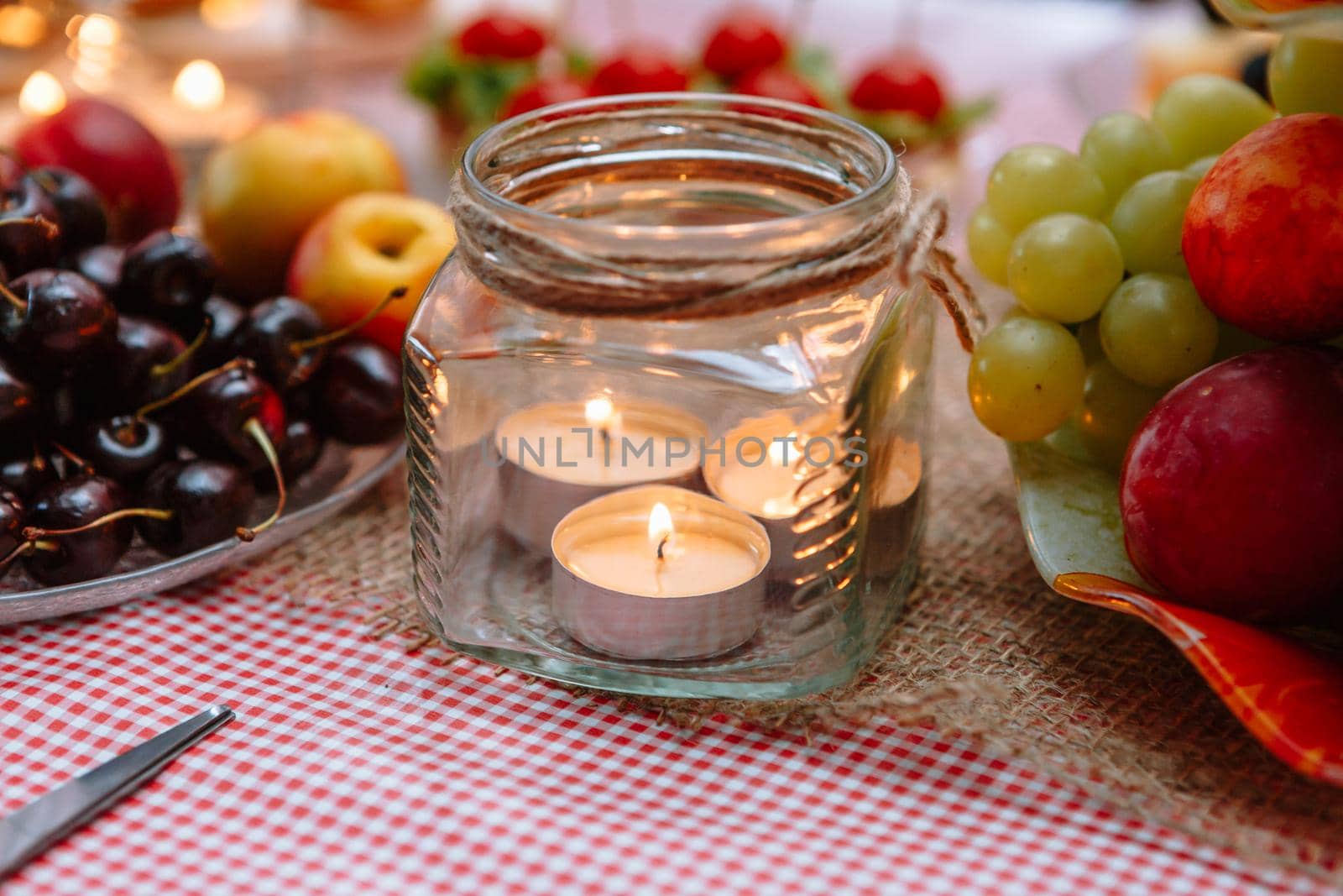 A transparent jar containing small burning candles