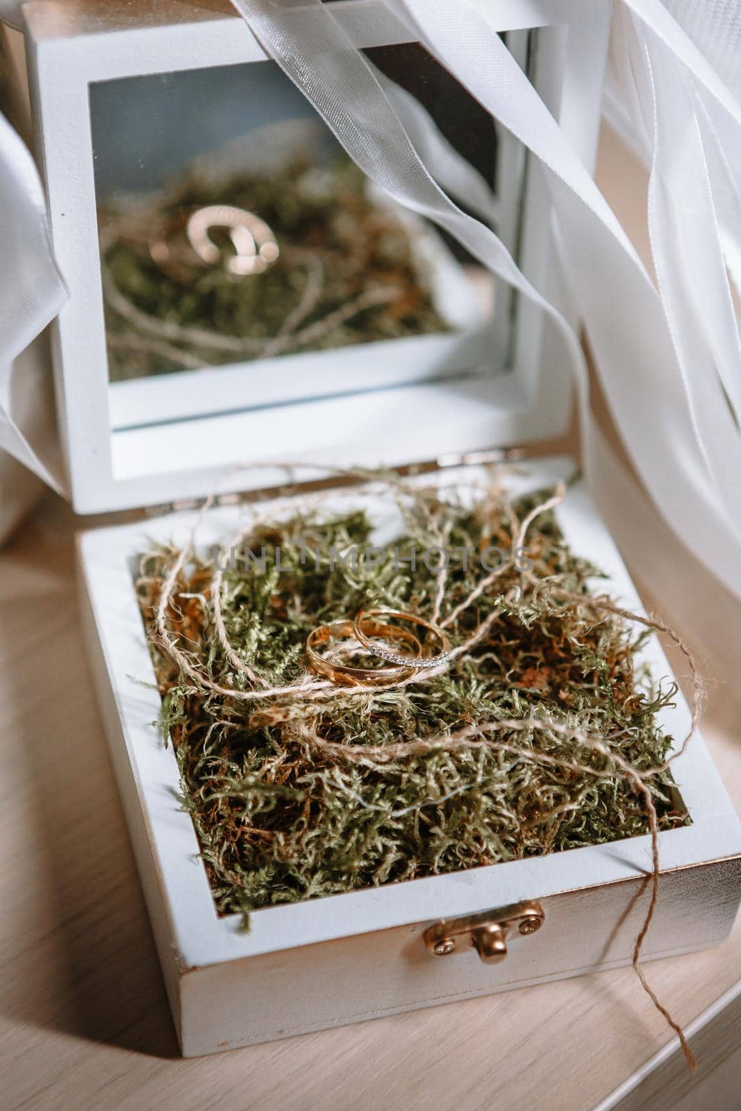 Gold wedding rings lying in a handmade white wooden box